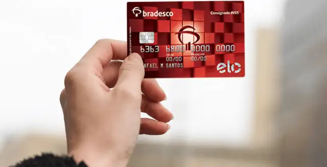 uma mão segurando o cartão Bradesco elo consignado
