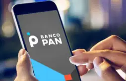 uma mão segurando um celular com o aplicativo Banco Pan