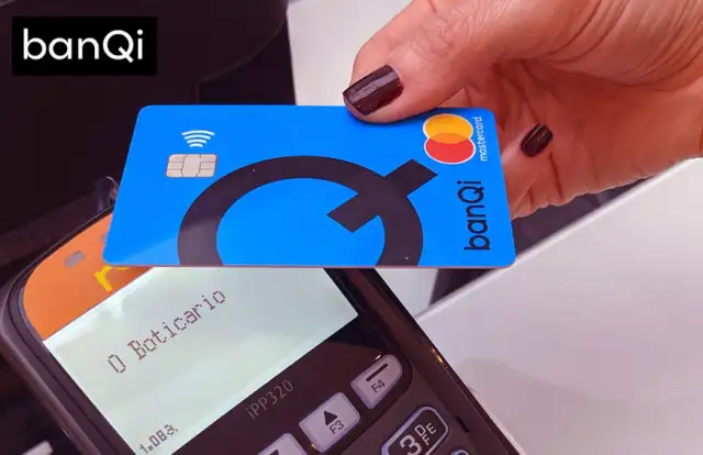 uma mão usando a função contactless do cartão pré pago banQi em uma maquininha