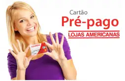uma mulher segurando o cartão pré pago Lojas Americanas