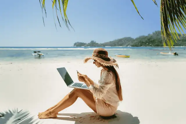 mulher com notebook na praia para representar Trabalhos freelancers