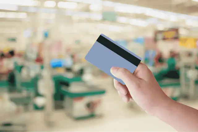 mão segurando um cartão de crédito para compras no supermercado
