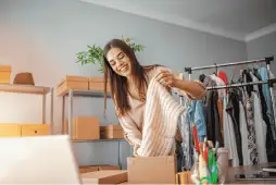 mulher colocando roupa em uma caixa por vender roupas usadas na internet