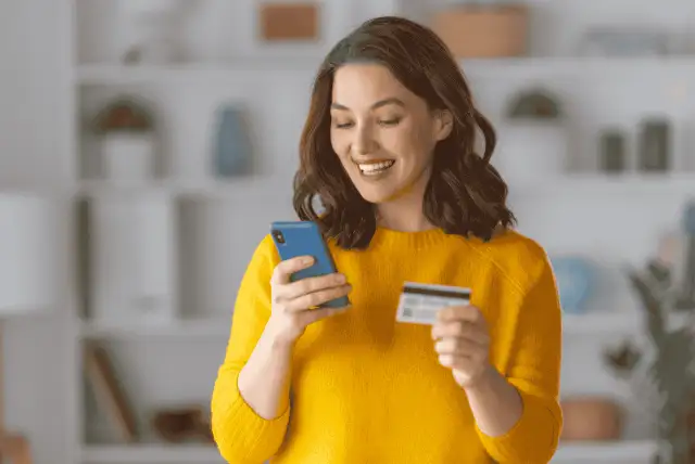 mulher feliz usando cartão de crédito para compras internacionais